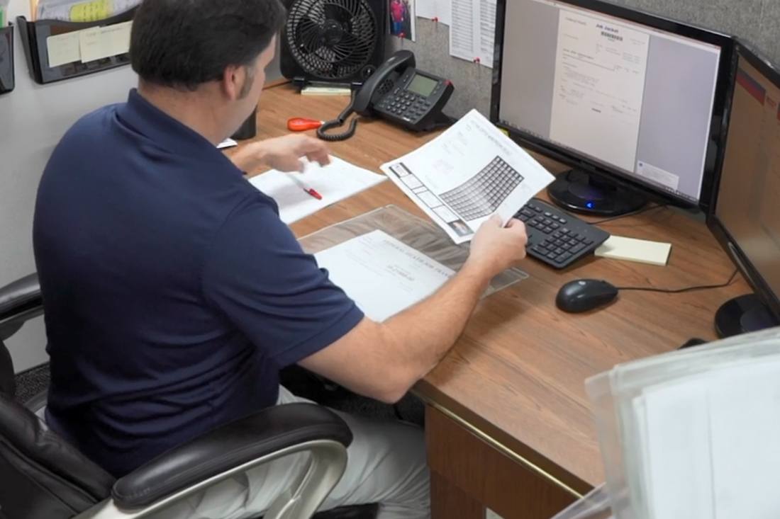 man sorting through paperwork at desk