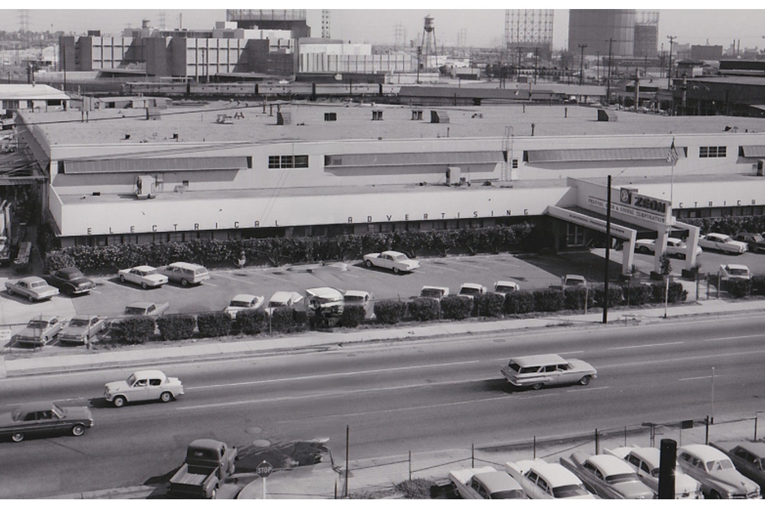 Black-and-white view of the Federal Electric facility beside a multilane road.