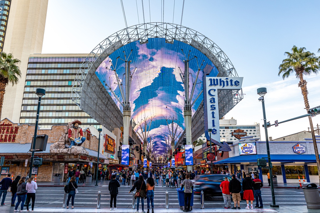 Colorful LED imagery across the Fremont Street Experience canopy above pedestrians in Las Vegas.