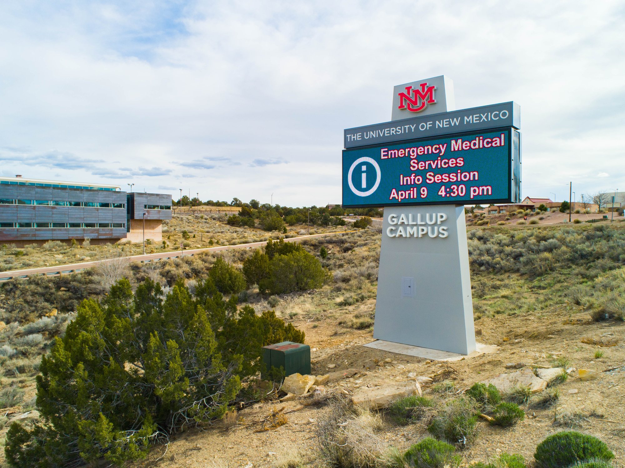 University of New Mexico Gallup Campus monument sign with an LED display promoting an emergency medical services information session.