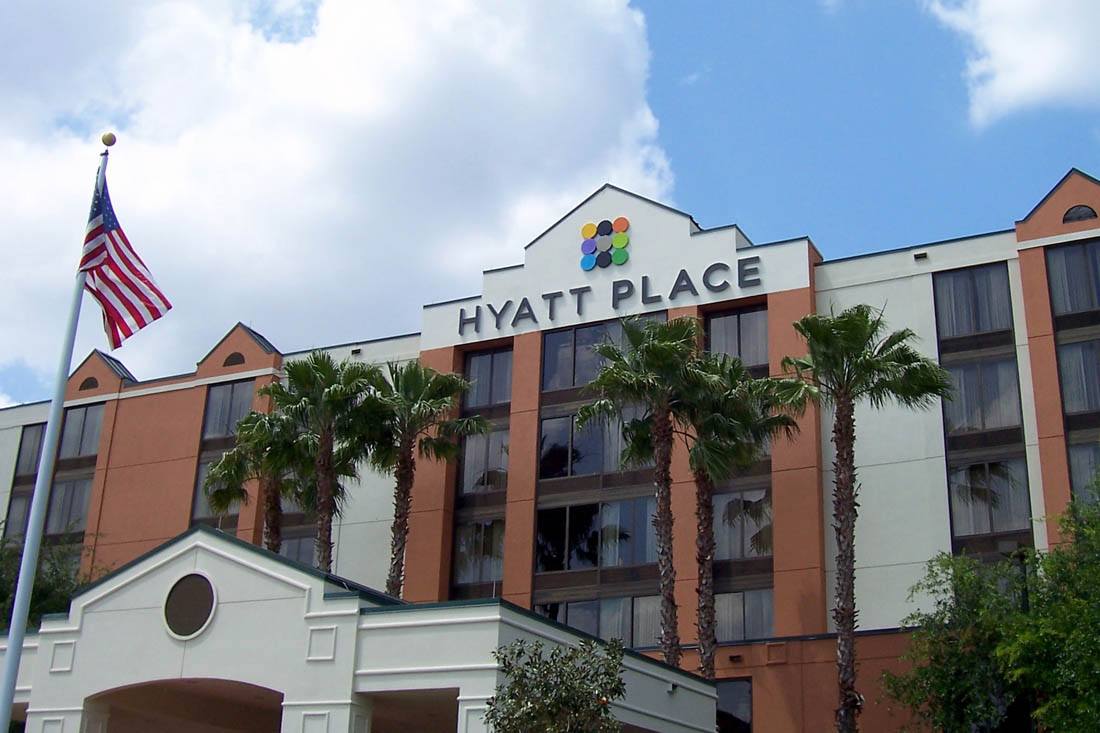 Hyatt Place hotel exterior with dimensional logo and lettering above palm trees.