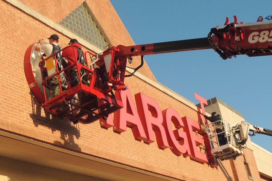 Workers repairing target channel letters