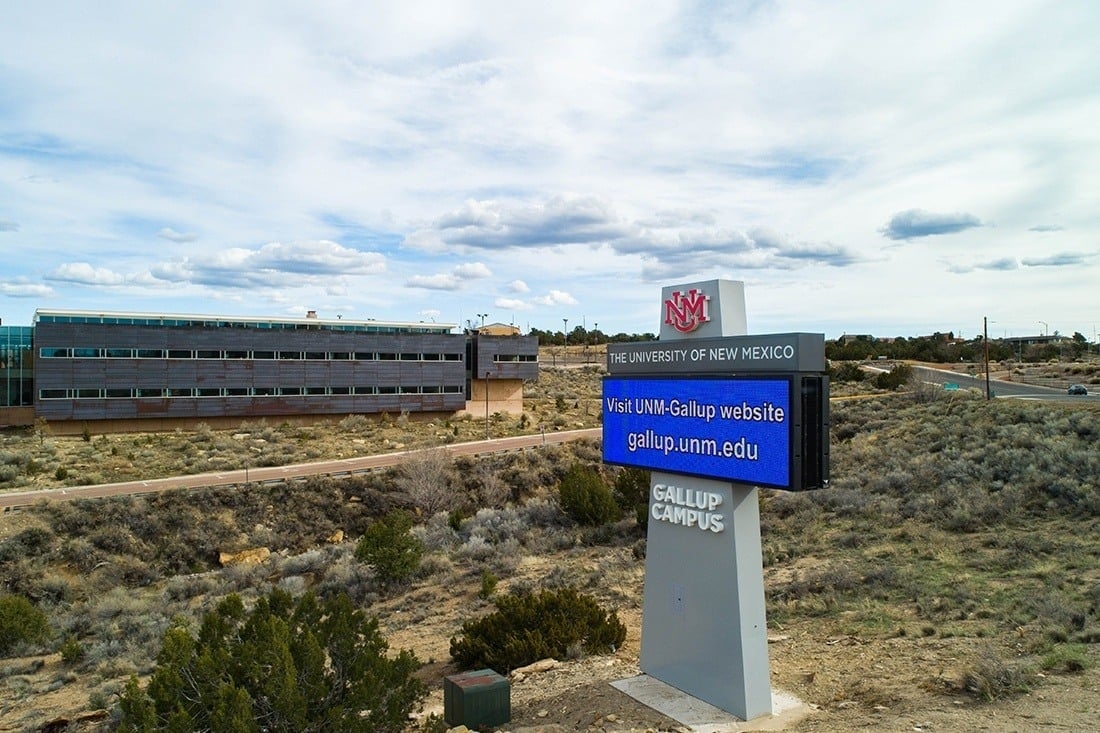 University of New Mexico Gallup Campus monument sign with a digital message display beside the campus roadway.