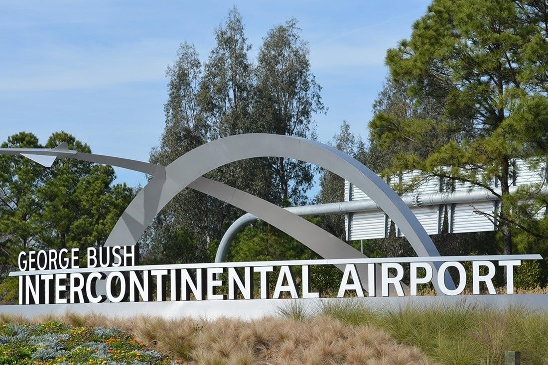 George Bush Intercontinental Airport entrance sign with large white letters and a sculptural metal arch.